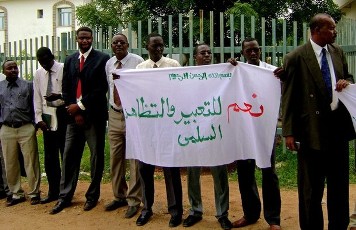 Sudanese lawyers hold a banner calling for freedom of expression and peaceful demonstration during a protest against the arrest of demonstrators outside the governor's house in the South Darfur capital of Nyala on July 16, 2012.
