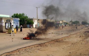 Smoke billows from burning tyres as Sudanese demonstrators protest against rising prices near the main market of Nyala, the capital of Sudan's South Darfur state, on 31 July 2012 (Photo: Getty Images)