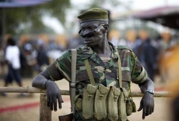 A SPLA officer keeps an eye on crowds gathered in Juba, (AP/file photo)