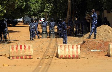 Riot police stand guard behind barbed wire placed around the French embassy after Friday prayers in Khartoum September 21, 2012. (Reuters)