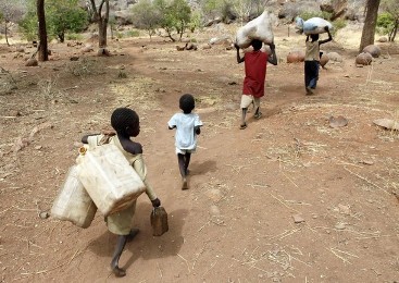 Children carry their family's belongings as they go to Yida refugee camp in South Sudan outside Tess village in the rebel-held territory of the Nuba Mountains in South Kordofan, May 2, 2012.  (Reuters)