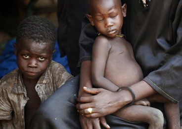 A woman holds her child in a shelter in Bram village in the Nuba Mountains, South Kordofan, April 28, 2012. (Reuters)