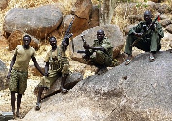 A SPLA-N fighter holds up his rifle near Jebel Kwo village in the rebel-held territory of the Nuba Mountains in South Kordofan, May 2, 2012.   (Reuters))