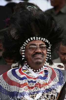 Sudan's President Al-Bashir, wearing a southern traditional dress, attends a protest with southern Sudanese against the ICC arrest warrant for him, in Khartoum March 7, 2009. (Reuters)
