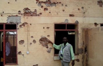 A Sudanese man displays damage in the aftermath of shelling by rebels in Kadugli on 11 October 2012 (AFP/File)