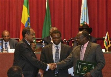 Sudan's chief negotiator Idris Mohamed Abdel Gadir (L) shakes hands with South Sudan's chief negotiator Pagan Amum after signing the cooperation agreement  on 27 September 2012 (Reuters)