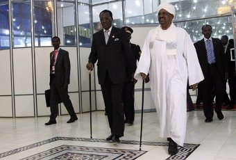 Chad president Idriss Deby walks with Sudan’s president Omer Hassan al-Bashir (R) after arriving at Khartoum Airport 7 February 2013. (REUTERS/Mohamed Nureldin Abdallah)