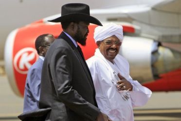 President Omer Al-Bashir (R) welcomes his South Sudanese counterpart Salva Kiir (C) during his arrival at Khartoum Airport on October 8, 2011 (Reuters)