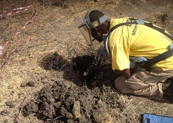 Cons Wani, an employee of the Danish Demining Group, clears mud from a rocket propelled grenade that landed in Bentiu town during the Sudanese civil war, March 4, 2013 (ST)