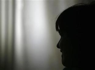 An unidentified girl, former sex slave, looks out in a shelter in this November 30, 2006 file picture. (REUTERS/Bogdan Cristel)