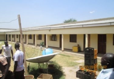 Traders admire the Diamond Complex Hotel, within area due to be demolished in Nimule, February 26, 2013 (ST)