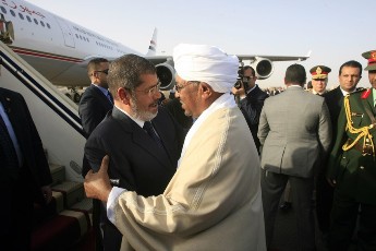 Sudanese President Omer Hassan al-Bashir (R) greets Egyptian President Muhammad Morsi upon his arrival in Khartoum on April 4, 2013.(ASHRAF SHAZLY/AFP/Getty Images)