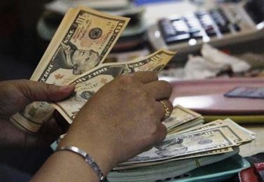 A worker counts US dollar bills inside a money changer in the Sudanese capital, Khartoum (Photo: Reuters)