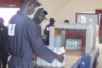 Workers taking crates of water from the production line at the water factory in Bor, Jonglei State, South Sudan, October 12, 2012 (ST)