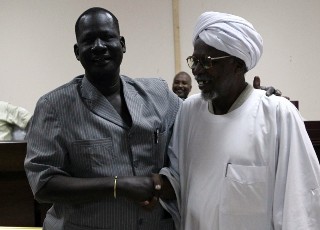 Al-Amer Mokhtar Papo (R) a leader of the Misserya Arab tribe and his counterpart from the Dinka Ngok tribe, Kuol Deng Kuol shake hands after signing a peace agreement in the town of Kadugli north of Abeyi on January 13, 2011. (KHALED DESOUKI/AFP/Getty Images)