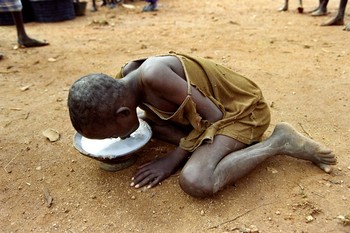 A Somalian child eats gruel in Baidoa on December 17, 1992 after US and French troops arrived on December 16 in what has been described as the epicentre of the famine (MICHEL GANGNE/AFP/Getty Images)