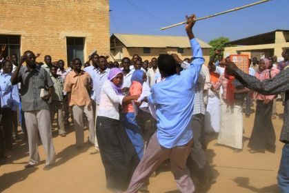 A Sudanese security agent holding a cane scuffles with Zalingei university  students in Central Darfur state after a protest diring the visit of Darfur mediators, (file photo/Getty)