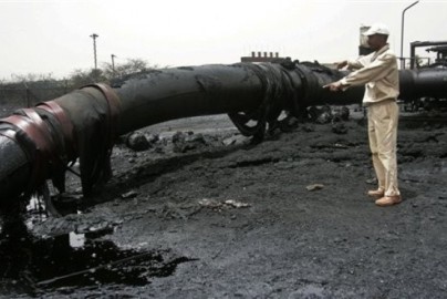 A Sudanese worker inspects burnt out oil pipes in Heglig on April 24, 2012. (AP)