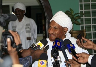 FILE - Sudan's President Omer Hassan al-Bashir smiles (L) as the leader of National Umma Party and former prime minister al-Sadiq al-Mahdi (REUTERS /Mohamed Nureldin Abdallah)