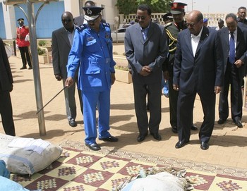 Sudanese President Omer Hassan al-Bashir is shown bags containing drugs as nations mark the International Day Against Drug Abuse and Illicit Trafficking in Khartoum on June 26, 2013. (ASHRAF SHAZLY/AFP/Getty Images)