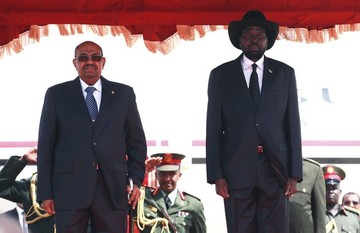FILE - Sudan's President Omer Hassan al-Bashir (L) and his South Sudan counterpart Salva Kiir (R) listen to their national anthems upon his arrival at the Juba Airport in South Sudan April 12, 2013. (REUTERS/Andreea Campeanu)