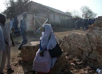 A Sudanese woman sits in front the wall that collapsed as thousands crowded to submit their applications for the annual hajj pilgrimage at the government office in the town on Gedaref, southeast of the capital Khartoum, on June 23, 2013 (STR/AFP/Getty Images)