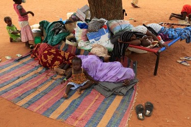 Displaced women and children from Abu Kershola rest at a school centre in Al-Rahaad, North Kordofan, 28 May, 2013 (Reuters)