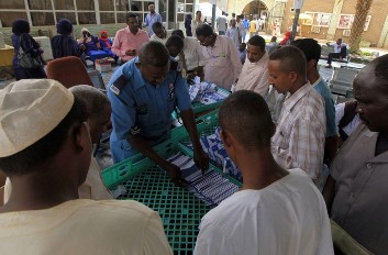 An officer delivers passports to Sudanese migrants at the Secretariat for Sudanese Working Abroad in Khartoum on 13 May 2013 (Photo: Reuters/Mohamed Nureldin Abdallah)