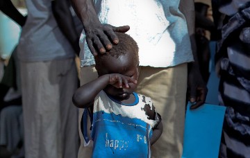 A boy who fled a war across the border in Sudan's Blue Nile state waits in a queue outside a clinic in Doro refugee camp, March 9, 2012. (REUTERS/Hereward Holland)