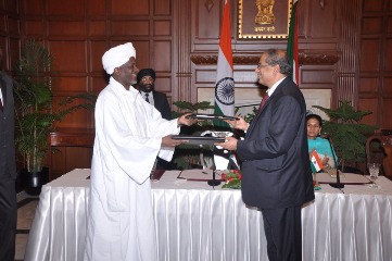 Sudan's minister of finance and national economy, Ali Mahmoud Abdel-Rasool, (L) and TCA Ranganathan, chairman & MD of Exim Bank, exchanging the signed agreement in New Delhi on 24 July 2013 (PHOTO: India Ministry of External Affairs)