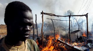 A SPLA soldier walks by an area destroyed by a Sudanese airstrike near the oil town of Bentiu (Photo: File/Reuters)