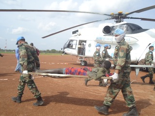 United Nations troops carry a wounded man at Bor airport. 14 July 2013 (ST)