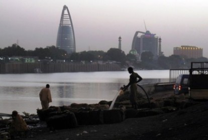 Sudanese men stand opposite the Greater Nile Petroleum Operating Company (GNOPC) building overlooking the Nile in Khartoum on April 18, 2010. (Photo PATRICK BAZ/Getty Images)