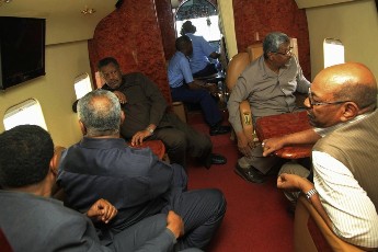 Sudan's President Omer al-Bashir (Bottom Right), Khartoum state governor Abdel-Rahman al-Khidir (Top Right), Presidential Affairs minister Bakri Hassan Saleh (Top Left) and other officials look out an aircraft window as they fly over an area affected by floods caused by heavy rains in Khartoum August 5, 2013 (REUTERS/Stringer)