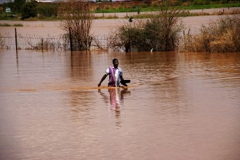 In this Saturday, Aug. 3, 2013 photo, a Sudanese man wades his way through flood water in Khartoum, Sudan. Heavy rains this week have flooded roads in the capital Khartoum and other parts of the country. (AP Photo/Abd Raouf)