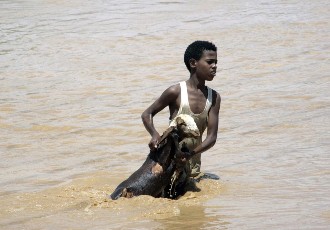 A young Sudanese boy holds a goat out of flood waters as he makes his way to higher land, on August 3, 2013, in Khartoum (EBRAHIM HAMID/AFP/Getty Images)