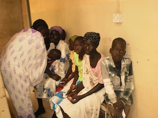 A mother and her children wait to see a doctor at Bentiu hospital, 31 August 2013 (ST)