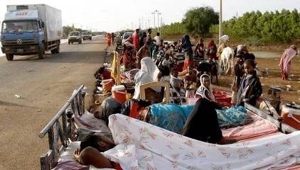 Flood victims take shelter on the side of a Khartoum road after floodwaters inundated their homes