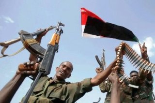 Sudan Armed Forces raise their weapons during a visit by President Omer al-Bashir to Heglig in 2012 (AP)