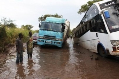 Truck drivers and passengers remain stranded in a flooded section of a road while driving from the Ugandan border into South Sudan at Nimule August 27, 2013. (Reuters/Andreea Campeanu)
