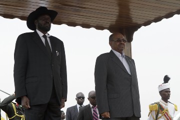 Sudanese President Omer Al-Bashir (R) attends a welcome ceremony with his South Sudan's counterpart Salva Kiir (L) upon his arrival at Khartoum airport on September 3, 2013 (ASHRAF SHAZLY/AFP/Getty Images)