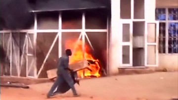 A man walks past a burning petrol station during a protest against a cut in fuel subsidies in the Omdurman district of Khartoum in this still image taken from video said to be taken September 24, 2013 (REUTERS/Kidintakar Radio Station/Storyful/via Reuters TV)