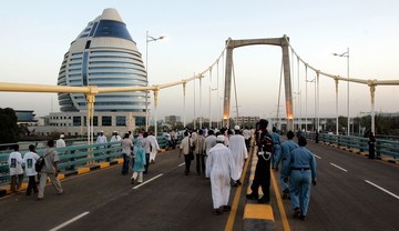 FILE - Sudanese people walk on the bridge linking the still largely rural island of Tuti in Khartoum with built-up areas on the banks of the Nile during its inauguration ceremony on March 21, 2009 (ASHRAF SHAZLY/AFP/Getty Images)