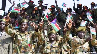 SPLA soldiers wave flags during the July 9 celebrations in Juba (Getty)