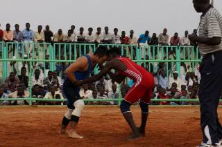 Japanese diplomat Yasuhiro “Muro” Murotatsu takes on his Sudanese opponent as part of a friendly wrestling match in Khartoum on 23 August