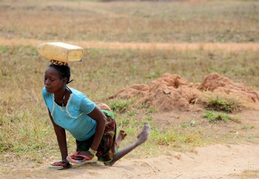 A woman, paralysed by polio, crawls to a water point in the Li-Rangu area, near the town of Yambio, capital of Western Equatoria State in South Sudan, on 20 October 2012 (Photo World Enabled).