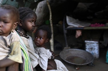 Children sit in front of their shelter in Bram village in the Nuba Mountains in South Kordofan on 28 April 2012 (Reuters)