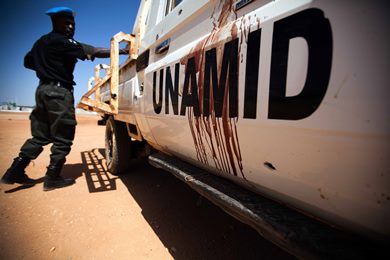 A Nigerian peacekeeper based in El Geneina, West Darfur, inspects a car, with remnants of blood, transporting Senegalese soldiers ambushed by unknown assailants. Three soldiers were killed on 13 October 2013 (Photo: Albert Gonzalez Farran/UNAMID)