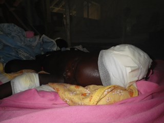 An infant boy shot by his father recovers in Bor hospital on 16 November 2013 (ST)