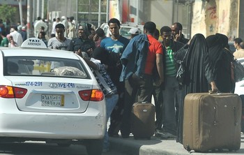 Foreign workers wait for a taxi as they leave the Manfuhah neighbourhood of the Saudi capital Riyadh on November 10, 2013, after two people have been killed in clashes between Saudi and other foreign residents the previous day, according to the Saudi police (FAYEZ NURELDINE/AFP/Getty Images)